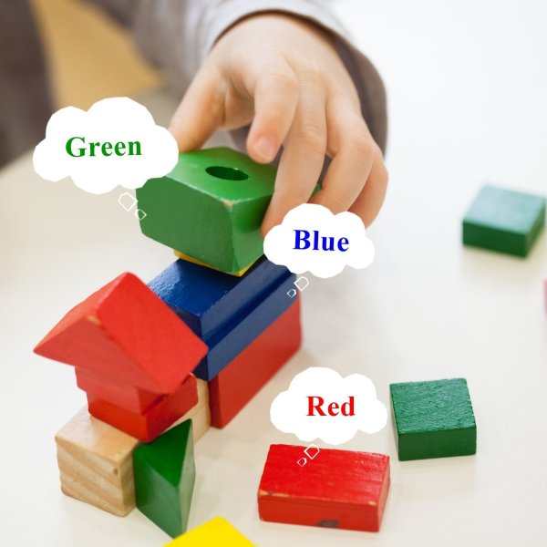 child play with colored wooden brick shapes on white table. close up view from above on hands and toys.